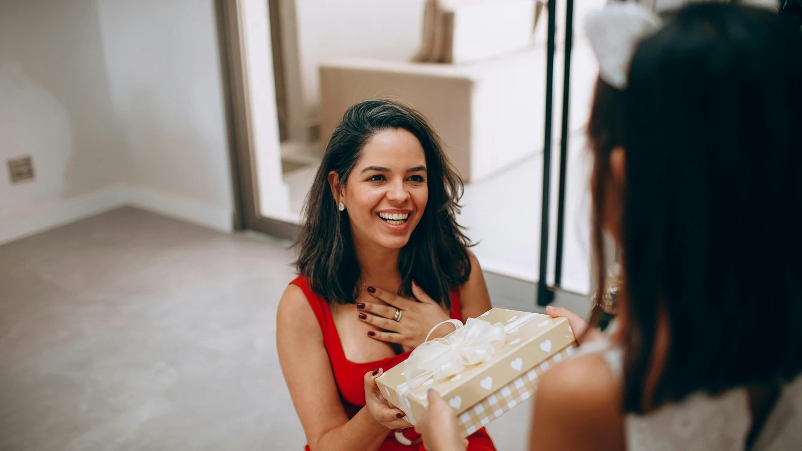 Maminka s úsměvem přijímá vánoční dárek od dcery